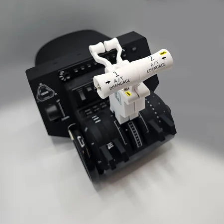 A black and white throttle quadrant, specifically the ProDeskSim Boeing 737 Advanced Full Package Addon/Modification for the Honeycomb Bravo, is displayed on a gray surface. The levers feature instructions for disengaging, and various buttons and dials can be seen, enhancing any flight simulation experience with Boeing 737 addons.