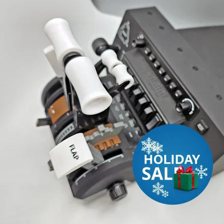 Close-up of an aircraft throttle quadrant showcasing the Boeing 777 Dual Action Detent/Spring mechanism by Prodesksim for the Honeycomb Bravo addon. This professional accessory features multiple levers labeled "FLAP" and "THROTTLE," in a black and gray color scheme, complete with several spring-loaded buttons and dial controls.