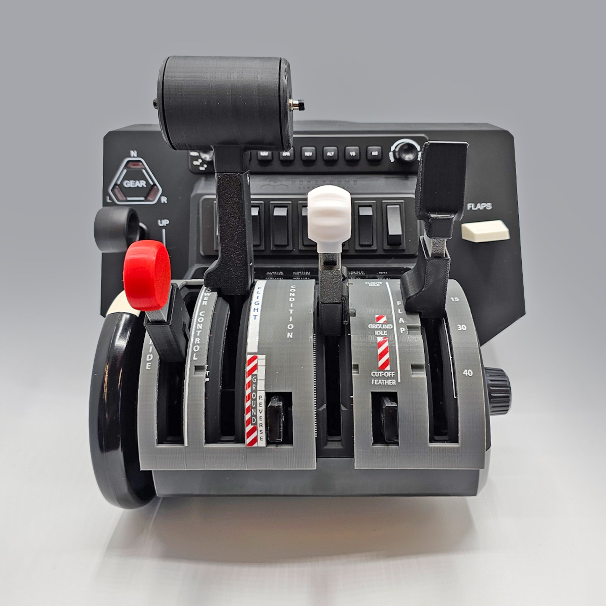 The NEW! ProDeskSim Pilatus PC-12 Addon/Mod package by Prodesksim for the Honeycomb Bravo Throttle Quadrant features a close-up of five colorful levers, tailored for various functions. The gray base includes gear and flap buttons, set against a simple light gray background.