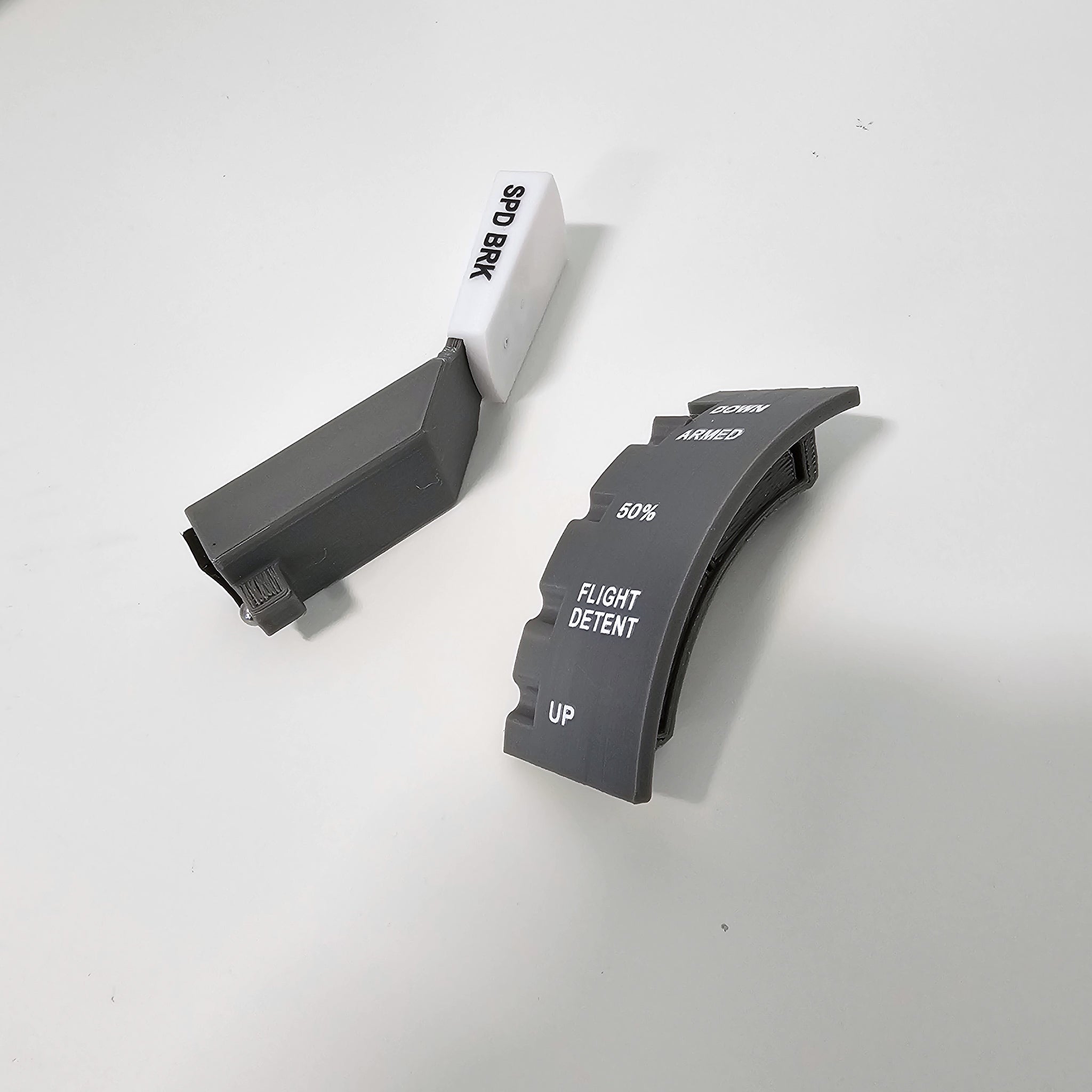 Two gray Prodesksim Boeing 737/757/767/777/787 Spring Loaded Speed Brake levers are shown on a white surface; one is labeled "SPD BRK," the other, a Honeycomb Bravo add-on, is marked "ARMED," "50%," "FLIGHT DETENT," and "UP.
