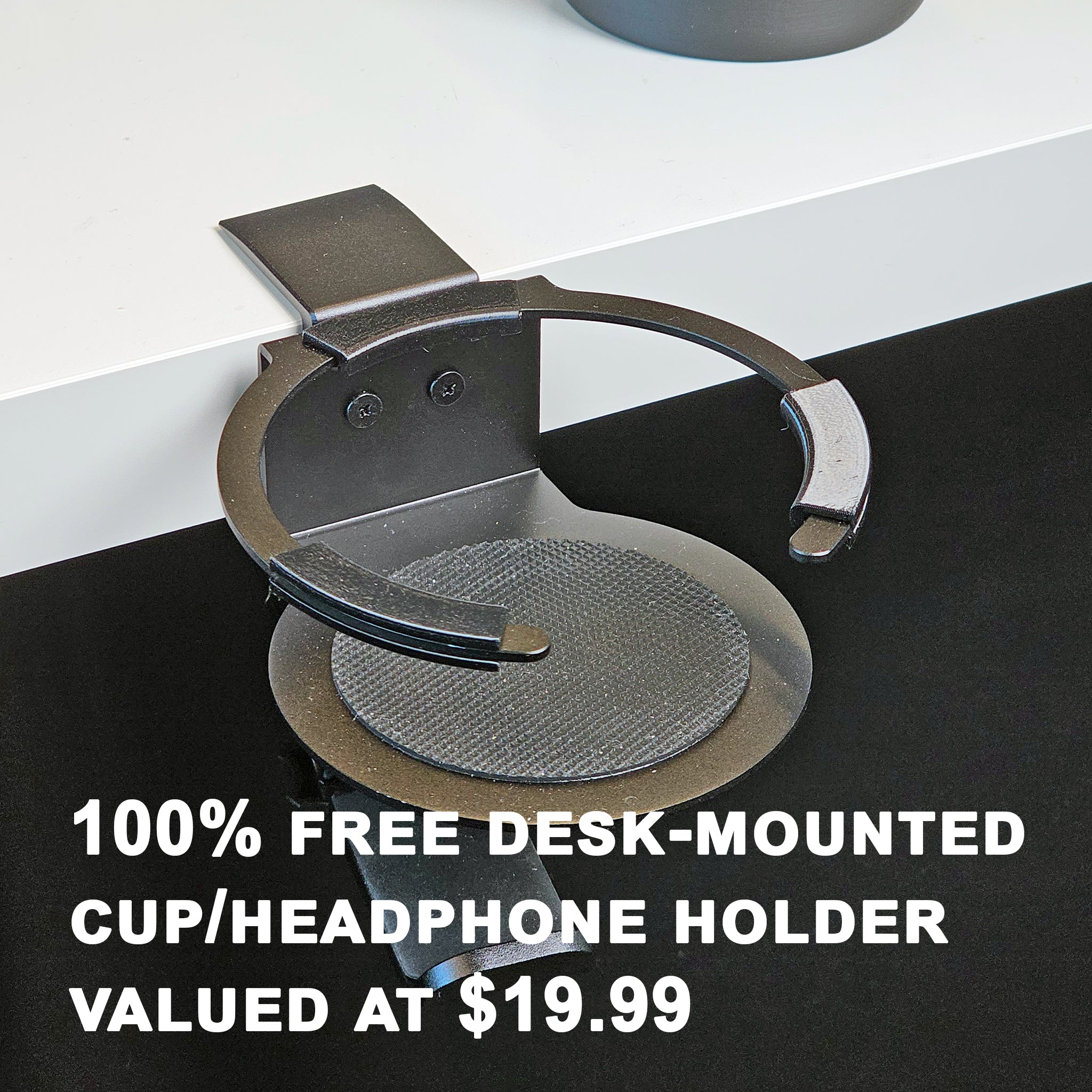 A black G58 Baron - The Cup Holder Flight Fidget from FlightFidgets.com attaches to the edge of a white desk, perfect for airplane enthusiasts. Text reads "100% Free Desk-Mounted Cup/Headphone Holder Valued at $19.99," making it an ideal fidgeting gadget for those on long flights.