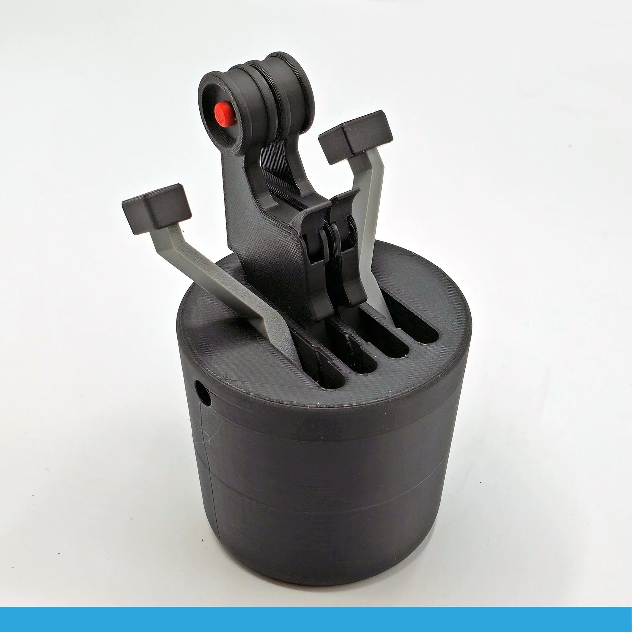 Introducing the AirBus 320 - The Cup Holder Flight Fidget by FlightFidgets.com: This sleek, black cylindrical object, expertly 3D-printed, features mechanical arms that mimic throttle levers and is accented with striking red highlights. Its grooved surface and contemporary industrial design offer a nod to aviation fans. The product is set against a clean white background for contrast.