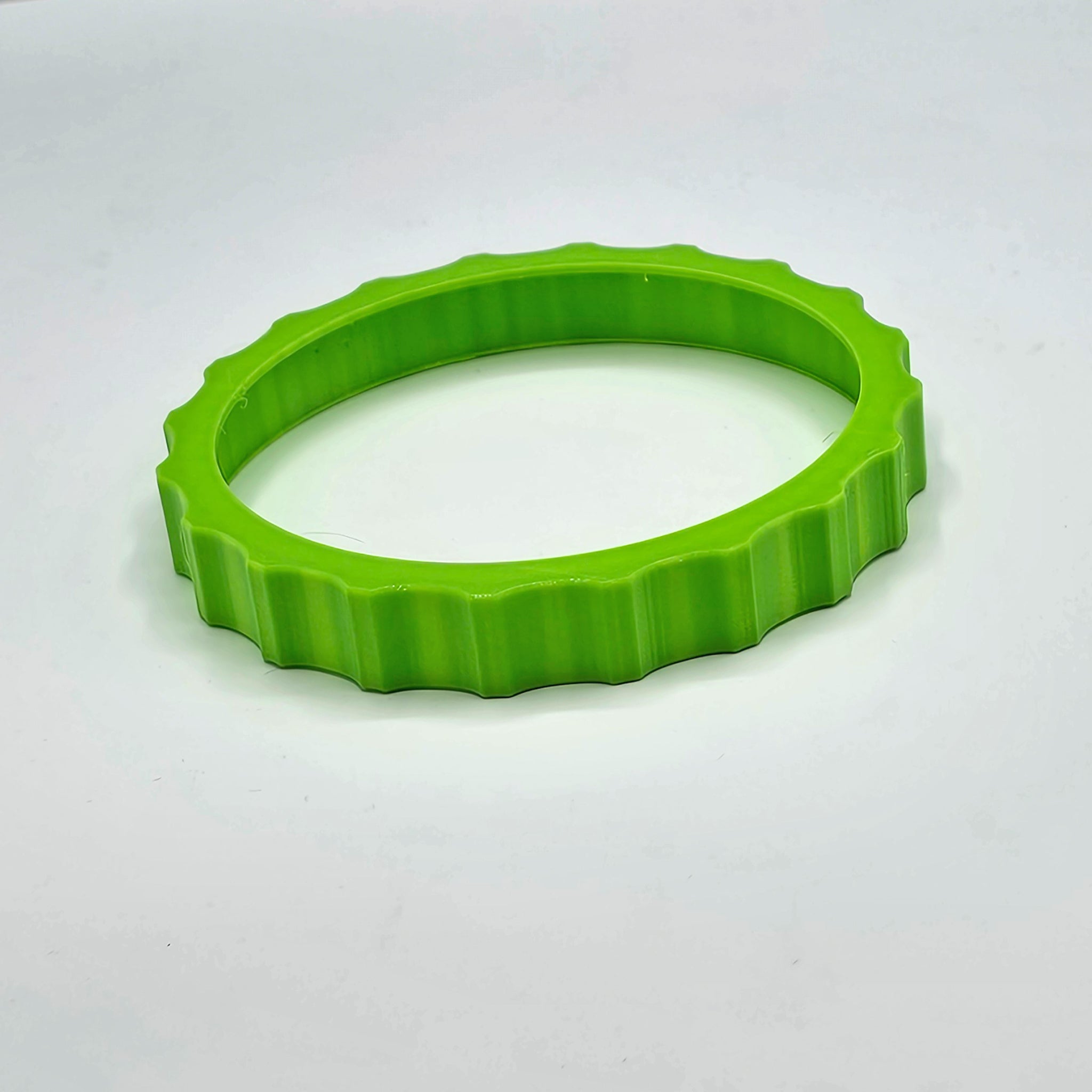 A vibrant and flexible green wheel cover, designed for the Honeycomb Bravo throttle quadrant, resembling a Prodesksim Trim Wheel Cover for flight simulation, is placed on a plain white background.