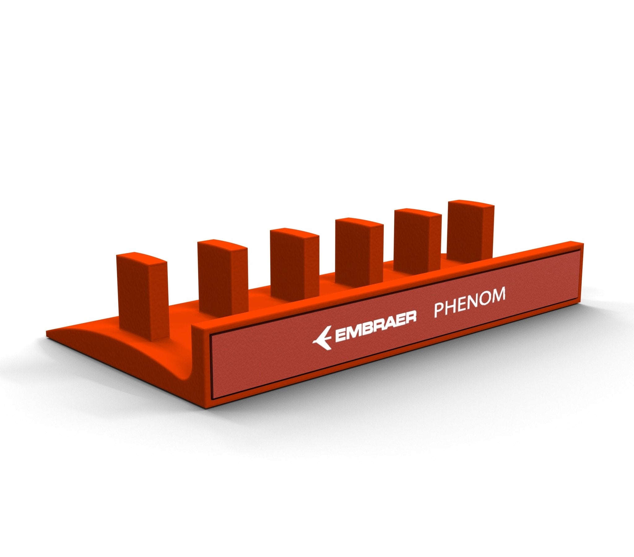 An orange plastic block designed as a stand/organizer features six raised rectangular pegs and the words "EMBRAER PHENOM" on the side, reminiscent of ProDeskSim levers found in aircraft, specifically for the Honeycomb Bravo Version by Prodesksim.