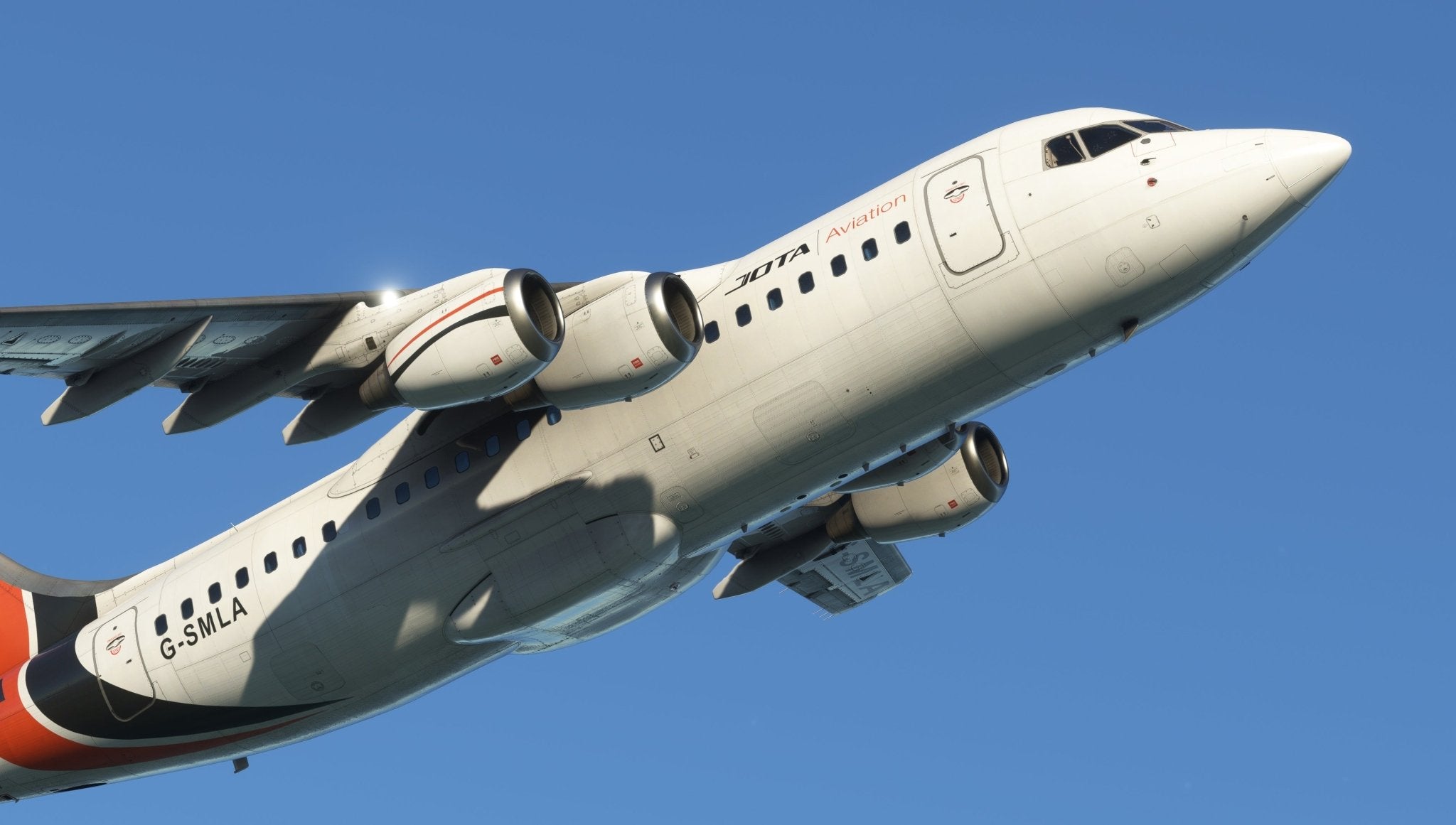 A Jota Aviation aircraft, reminiscent of the Just Flight BAE-146 Professional for MSFS2020, glides effortlessly through a clear blue sky. Its white exterior, highlighted with black and red accents, is captured from below, showcasing its engines and part of the fuselage elegantly in mid-flight.