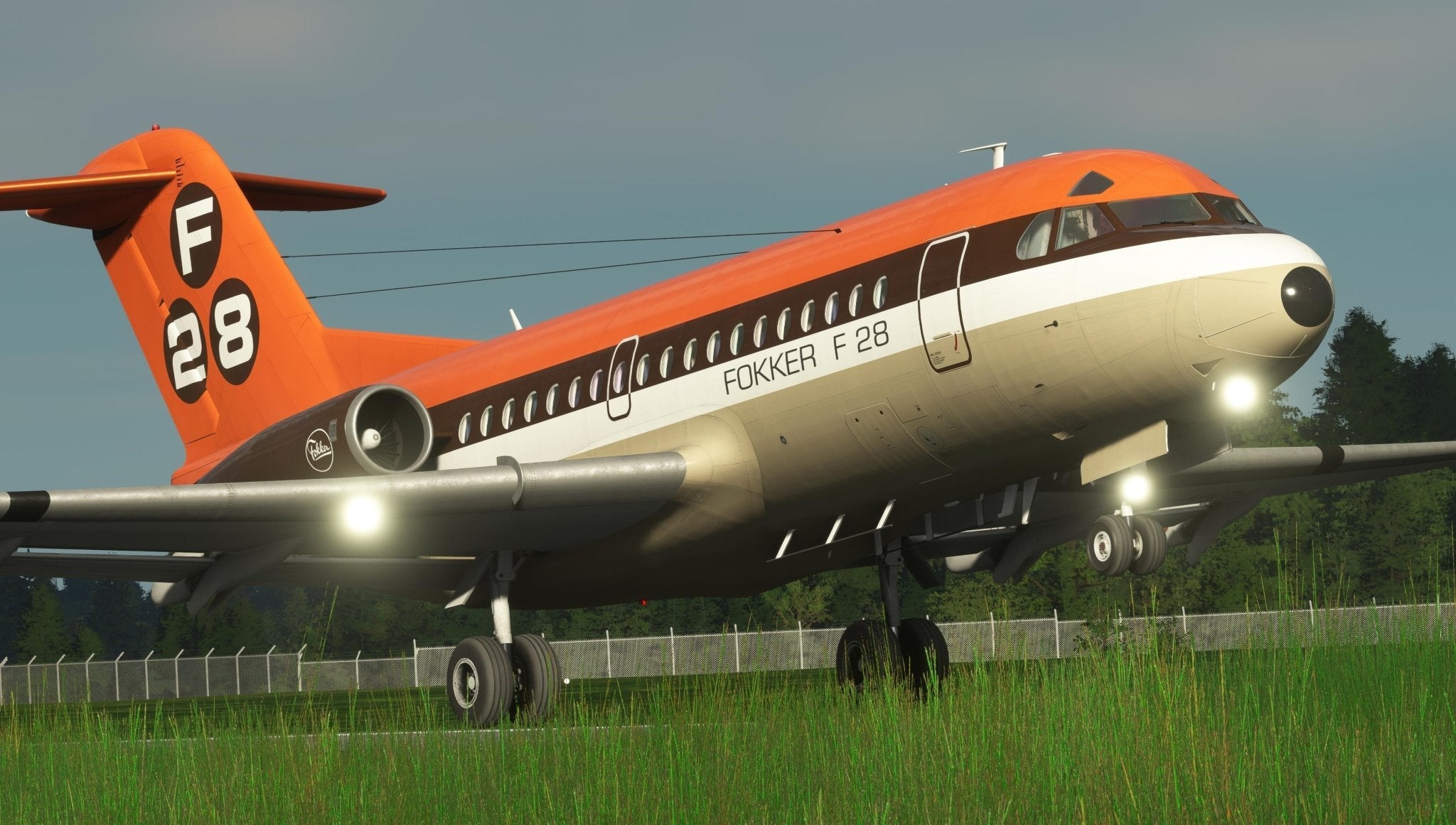 A Just Flight Fokker-28 Professional for MSFS2020, featuring a vibrant orange and white livery, is poised for takeoff on the runway. The aircraft's landing gear is set against a backdrop of lush green grass and a fence, highlighting the distinctive elements of Just Flight's F28 Professional series.