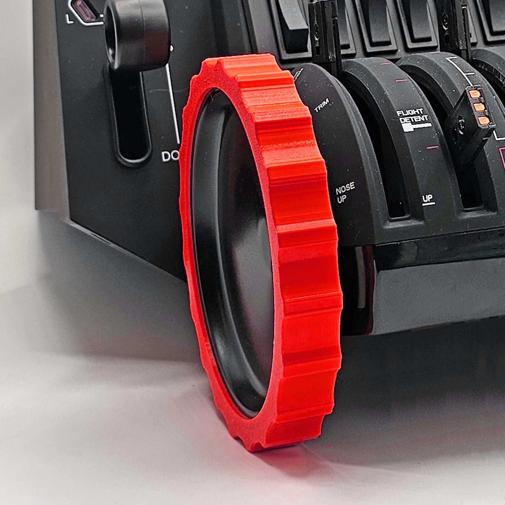 Close-up of a Prodesksim 1 Color Vibrant and Flexible Trim Wheel Cover, prominently displayed on a Honeycomb Bravo Throttle Quadrant. The throttle levers and control markings are clearly visible, indicating settings for various flight maneuvers in the world of flight simulation. The background reveals part of the simulator's body.