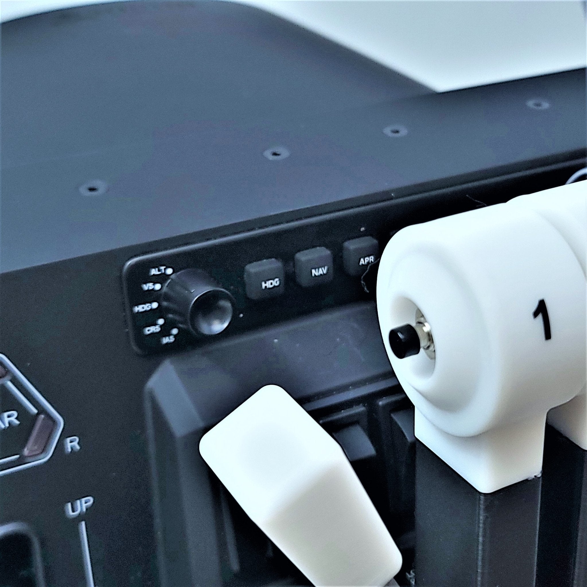 Close-up of a Prodesksim BAE-146 throttle quadrant flight simulator cockpit control panel featuring various buttons, switches, and four white throttle levers labeled "#1". The black panel includes labels for ALT, HDG, NAV, and APR functions.