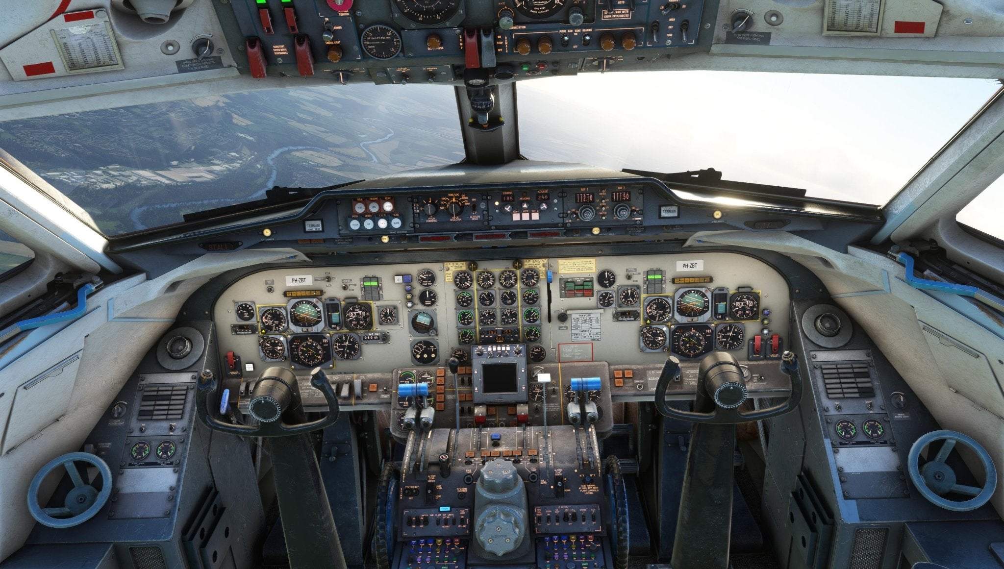 A glimpse inside the cockpit of the Just Flight Fokker-28 Professional for MSFS2020 uncovers a multitude of dials, switches, and controls. The two pilot seats are surrounded by an array of instruments and screens from Just Flight's newest regional jet simulation, with windows offering views of the landscape below.