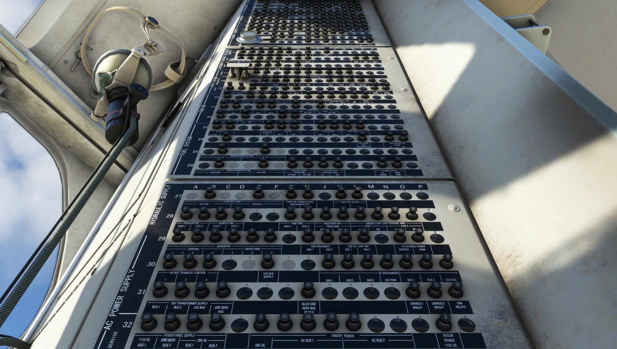 A close-up view of a sophisticated control panel with numerous switches and dials, reminiscent of those in the Fokker-28 Professional cockpit by Just Flight for MSFS2020. Nearby, wires and a headset hang, suggesting an environment inspired by Just Flight's technical realism. Bright sunlight casts shadows on the metallic surface.